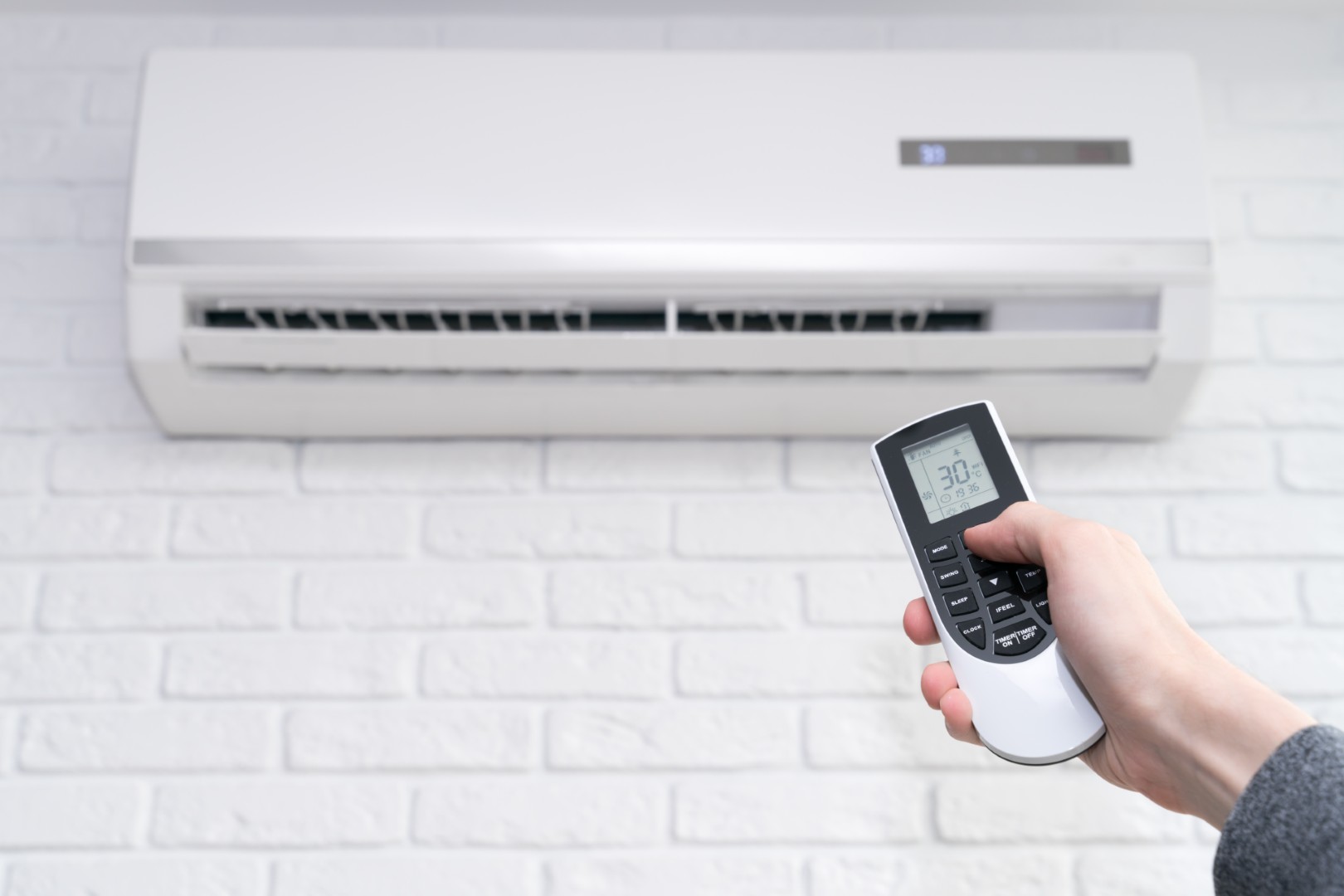 Conversion De Chauffage Au Mazout À L’électricité Home Air Conditioner And Hand With Remote Control 2025 03 10 00 47 58 Utc